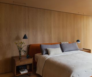 bedroom with natural oak wood wall and white bedliinen