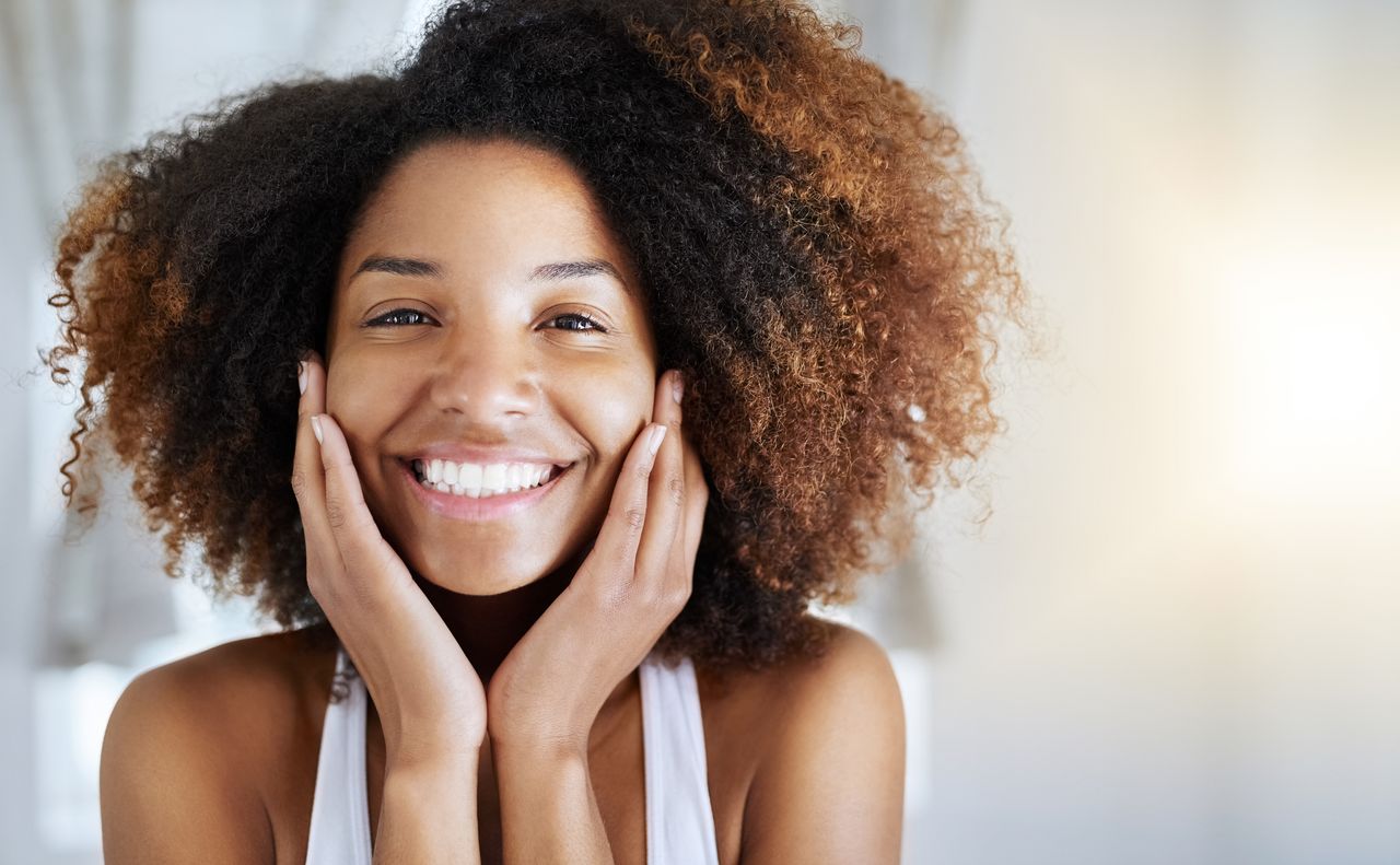 girl touching her face with gorgeous glowing skin