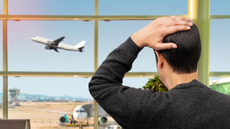 Man looking at departing flight in distress