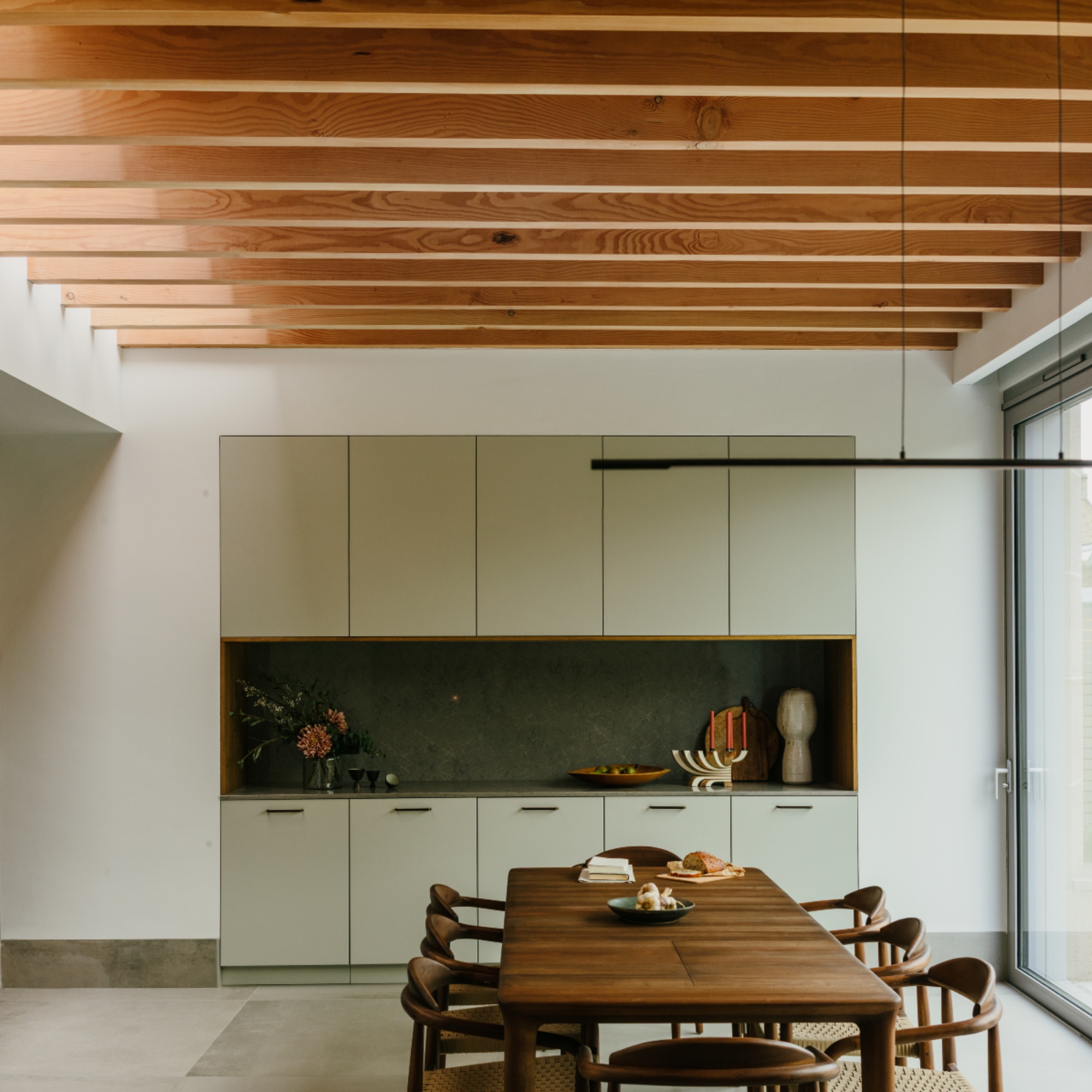 kitchen dining space with long dining table and chairs, dining room storage