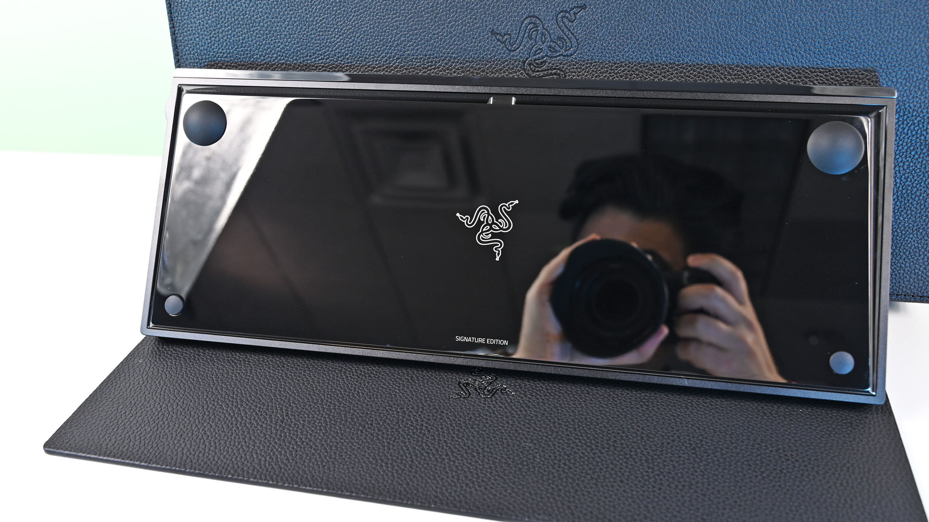 The reflective, glossy black underside of the keyboard featuring a centered white Razer logo and the text "SIGNATURE EDITION" at the bottom.