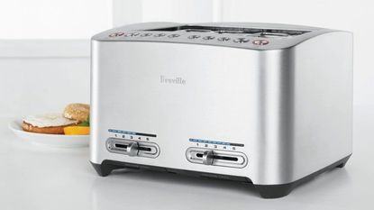 A Breville Die Cast 4-Slice Toaster next to a bagel