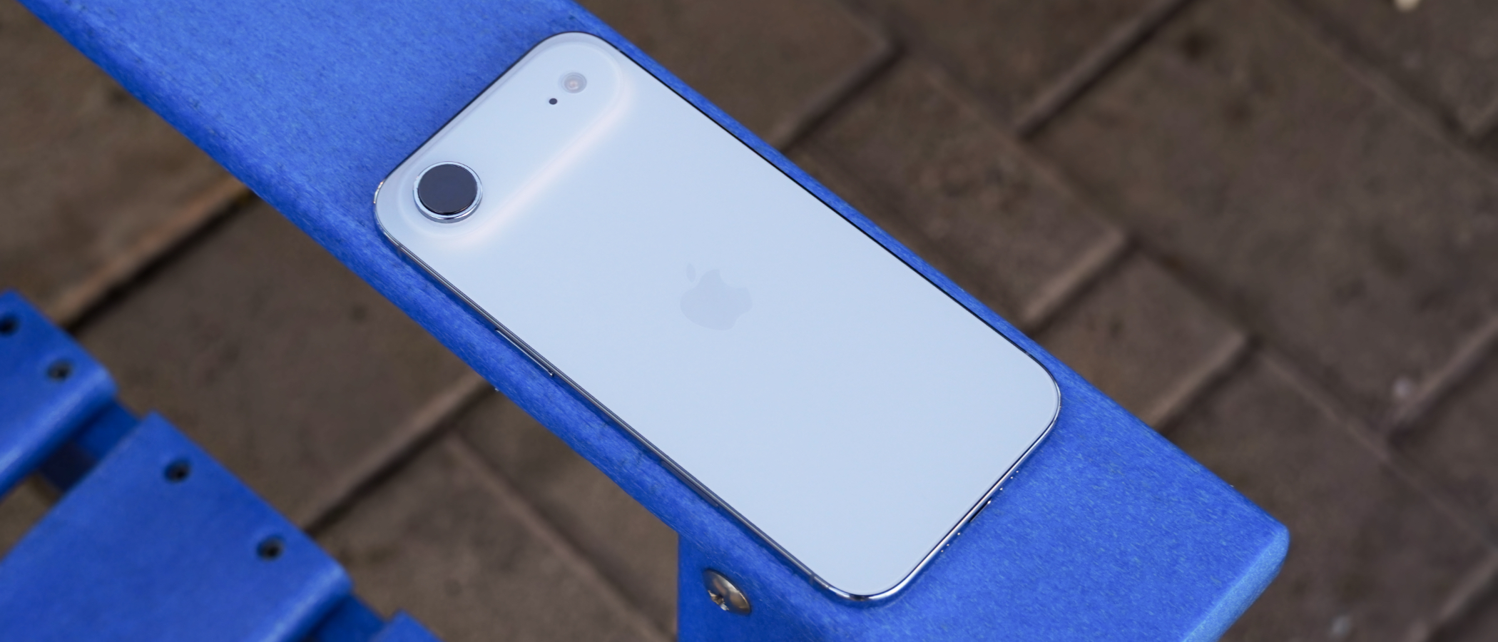 The back of an iPhone Air in Sky Blue on a blue chair. 