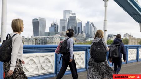 People walk over the Thames with the City of London in the background before the UK general election (Photographer: Jason Alden/Bloomberg via Getty Images)