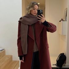 Influencer wears a burgundy coat.