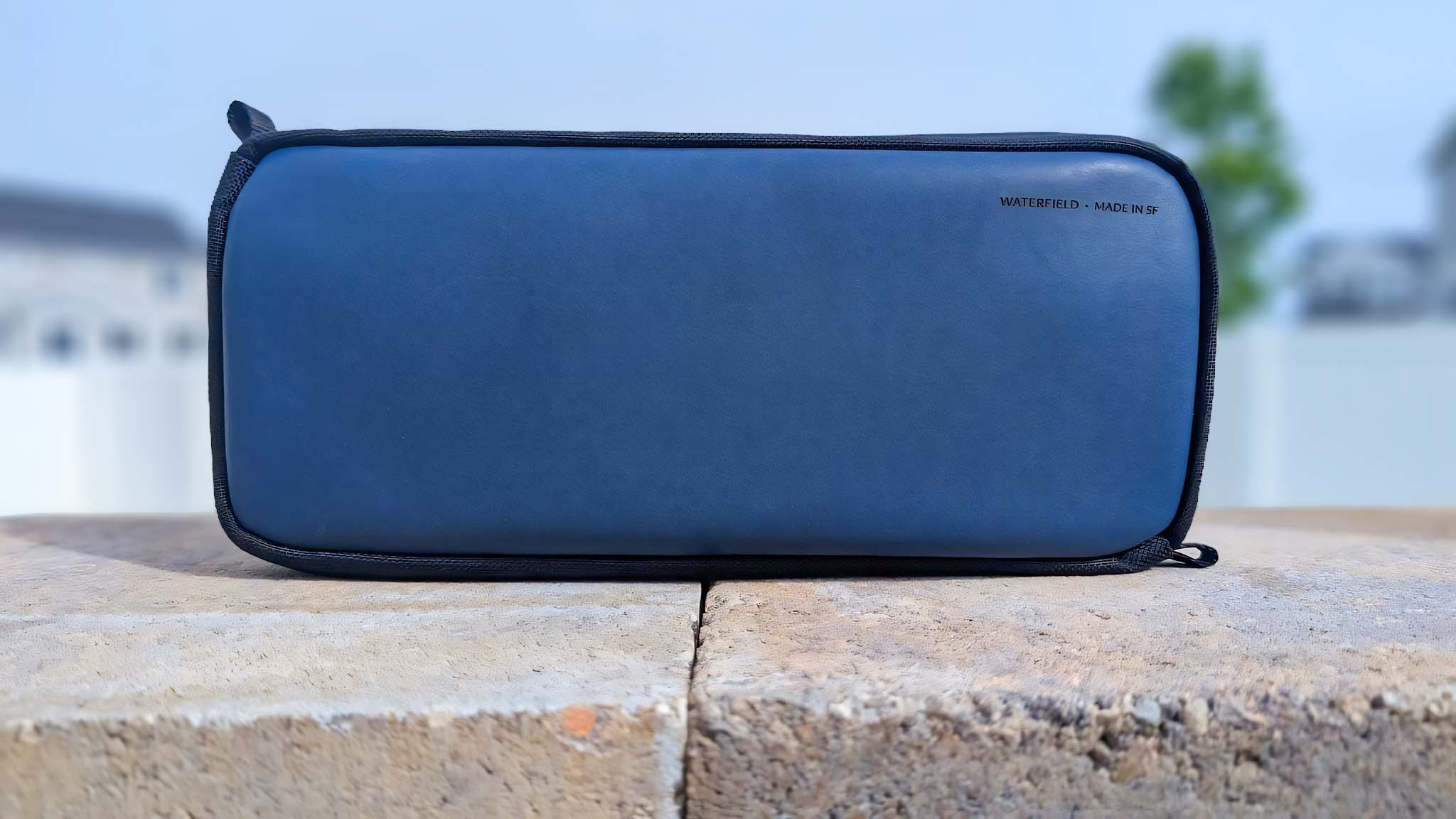 The Waterfield ROG Ally X Magnetic Case standing upright on bricks in an outdoor setting.
