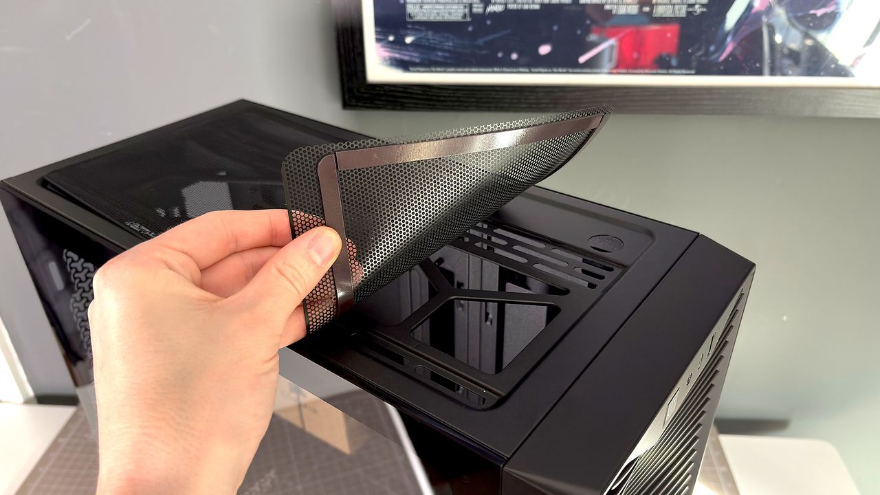 A Corsair PC case, the 3200D, on a desk with various panels removed and ready for a PC build.