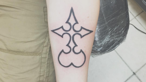 Curvy cross tattoo