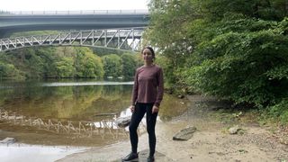 Julia Clarke wearing the Columbia Women's Sloan Ridge Graphic Long Sleeve Technical T-Shirt by the river