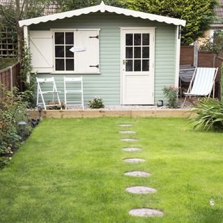 lawn with grass and shed with white door and window