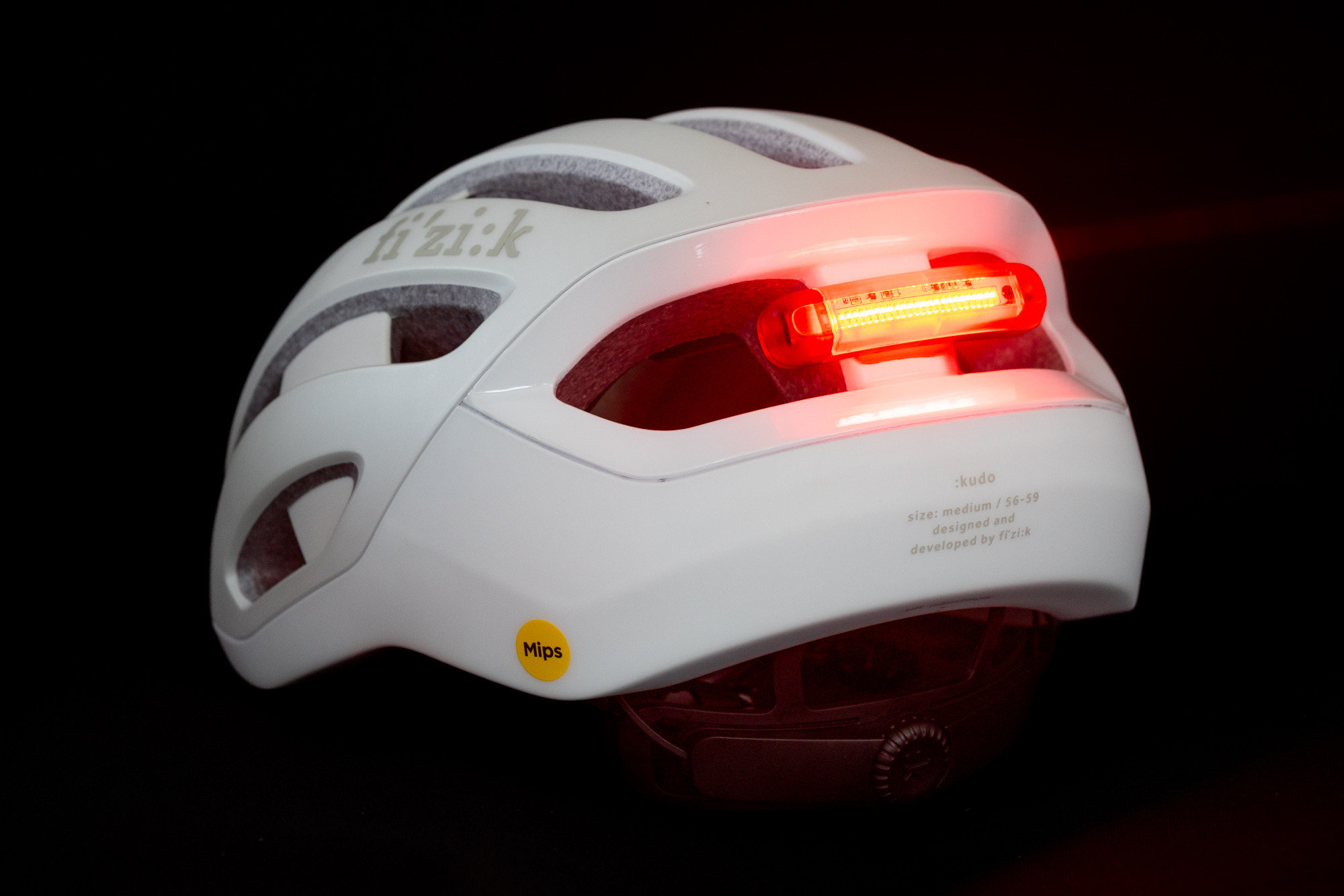 image shows a white Kudo helmet from the rear with the integrated red light on