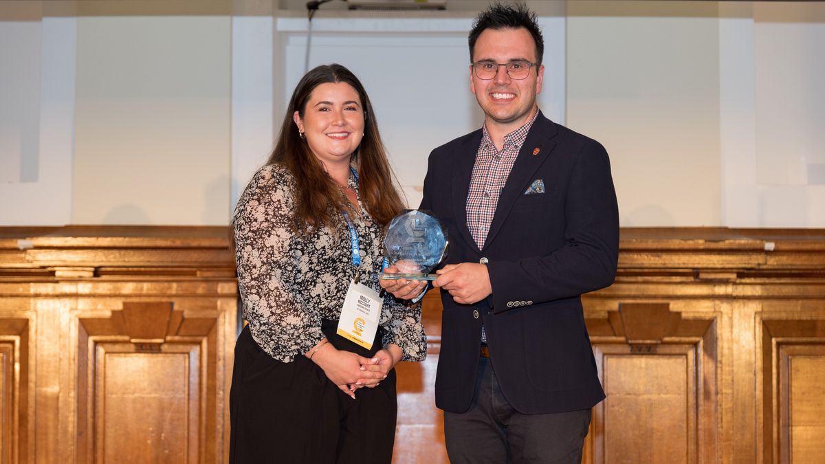 Photographer Jack Boskett receiving the Christmas Parties and Seasonal Events category trophy at the Event Photography Awards 2026 ceremony from Molly McCourt f