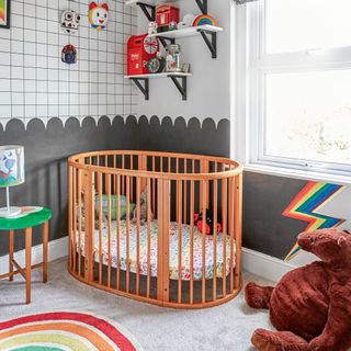 Nursery with black and white colour scheme, wooden cot and masks on wall