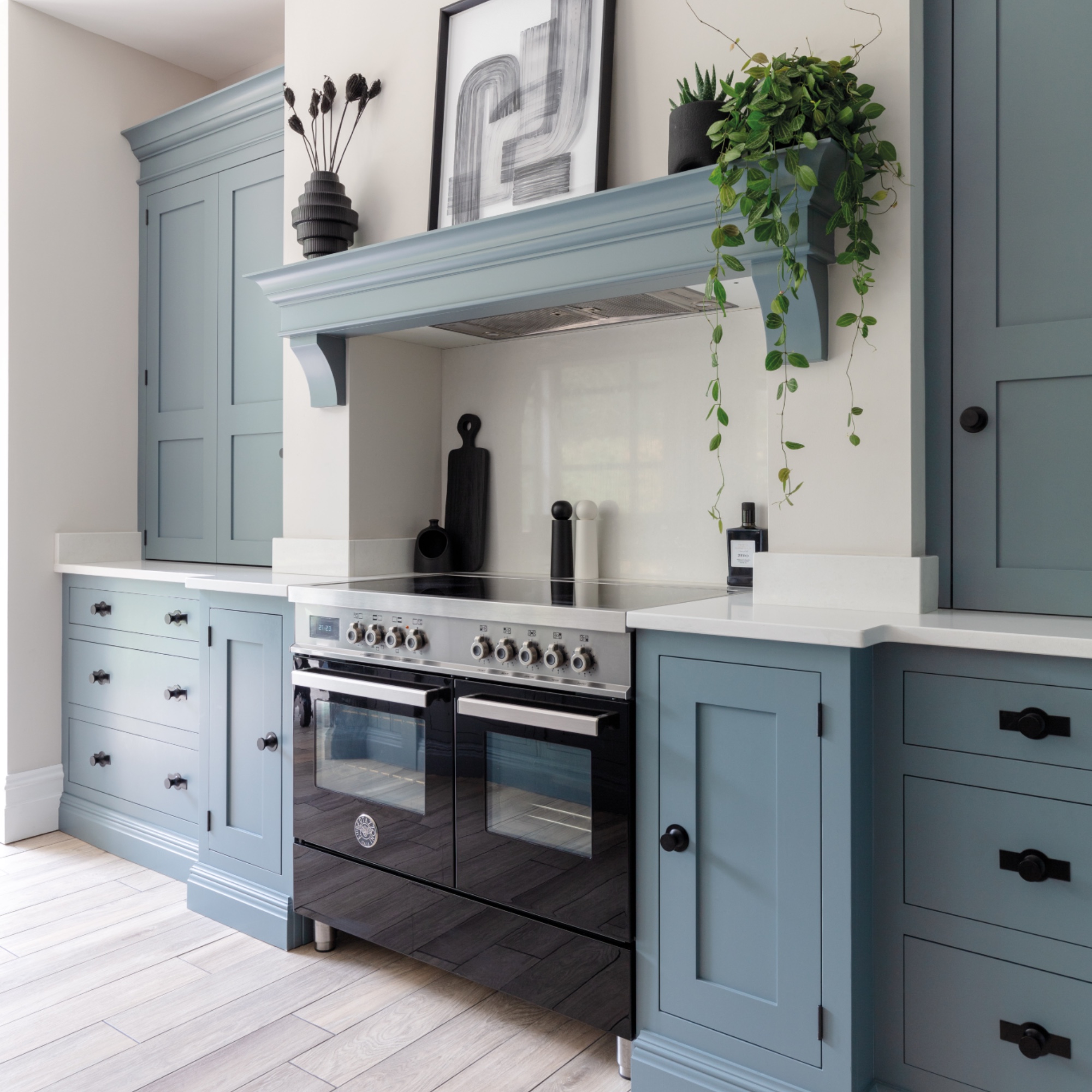 blue kitchen with storage solutions, large kitchen island, black range