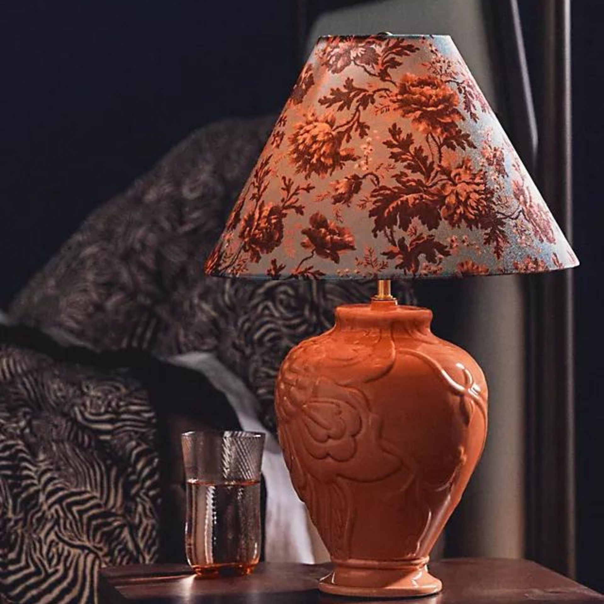 A peach lamp with a floral patterned shade