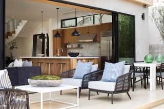 porch design ideas with black furniture, white table and a pale stone deck