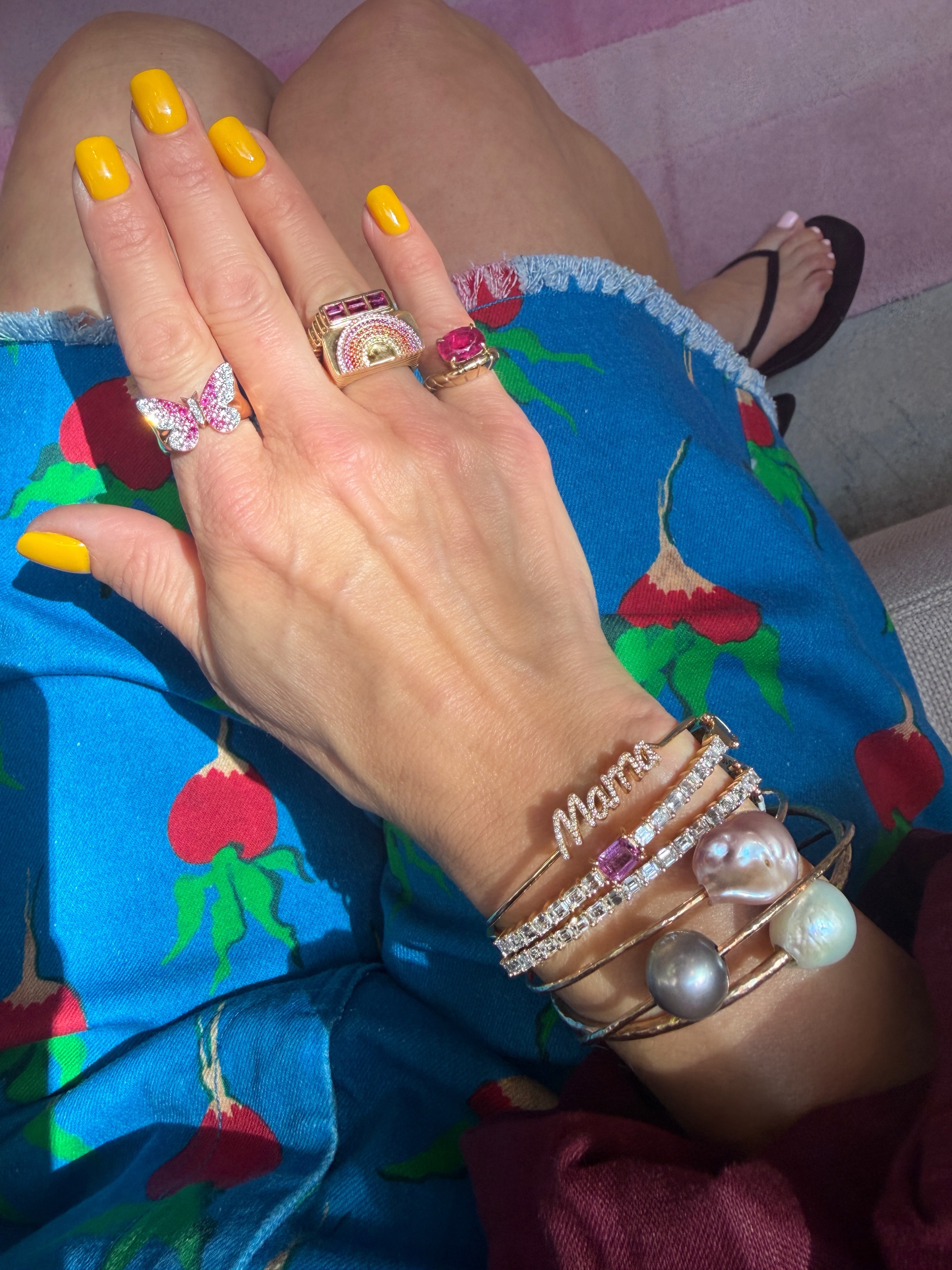 Bright citrus-inspired nail art paired with a colorful outfit and stacks of statement rings and bracelets