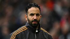 Former manchester united head coach ruben amorim stands against blurred background, frowning