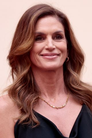 Cindy Crawford is pictured with golden face-framing highlights in her brunette hair at the opening night of OMEGA House Paris 2024 on July 27, 2024 in Paris, France.