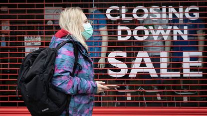 Woman walking past a closing-down shop