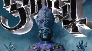 Ghost singer Papa V Perpetua, standing in front of the Ghost logo