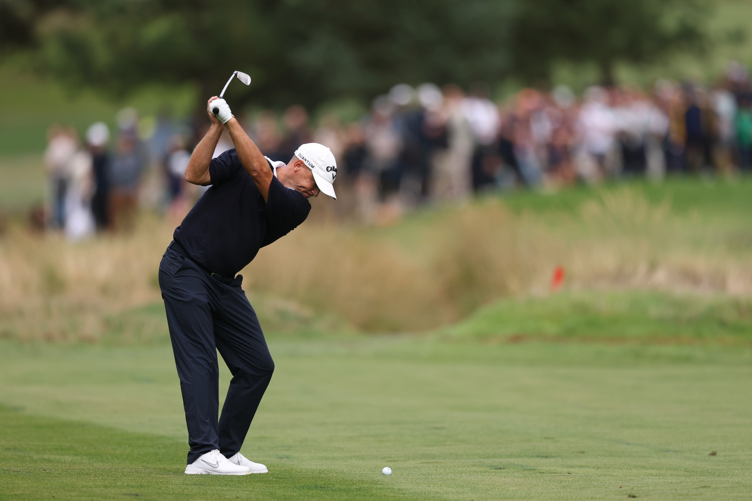 Alex Noren from behind hitting an iron shot