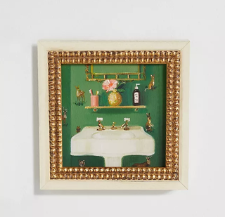 A painting of a bathroom sink in a gold beaded frame