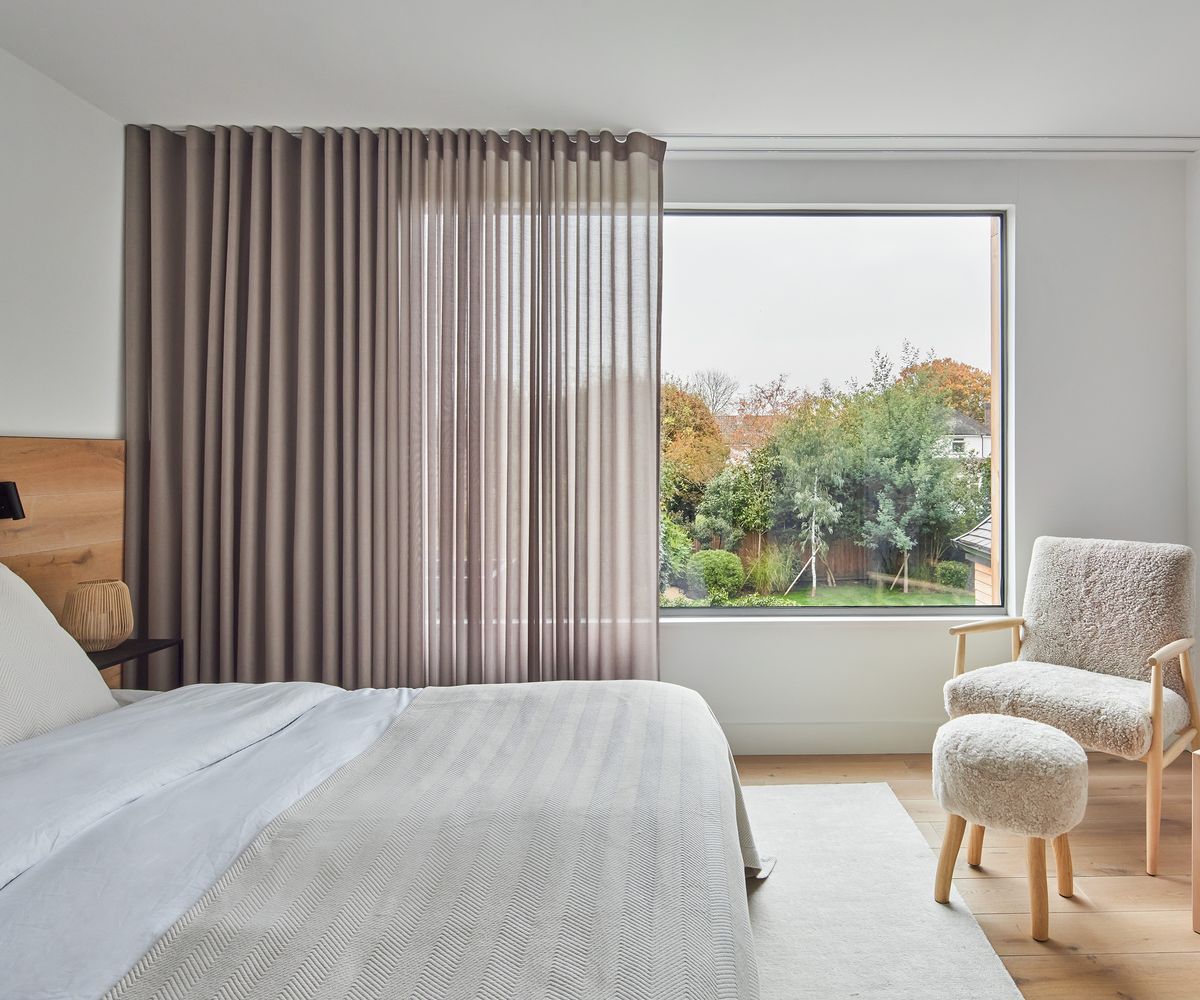 A light double-bedroom with large picture window with a sheer curtain