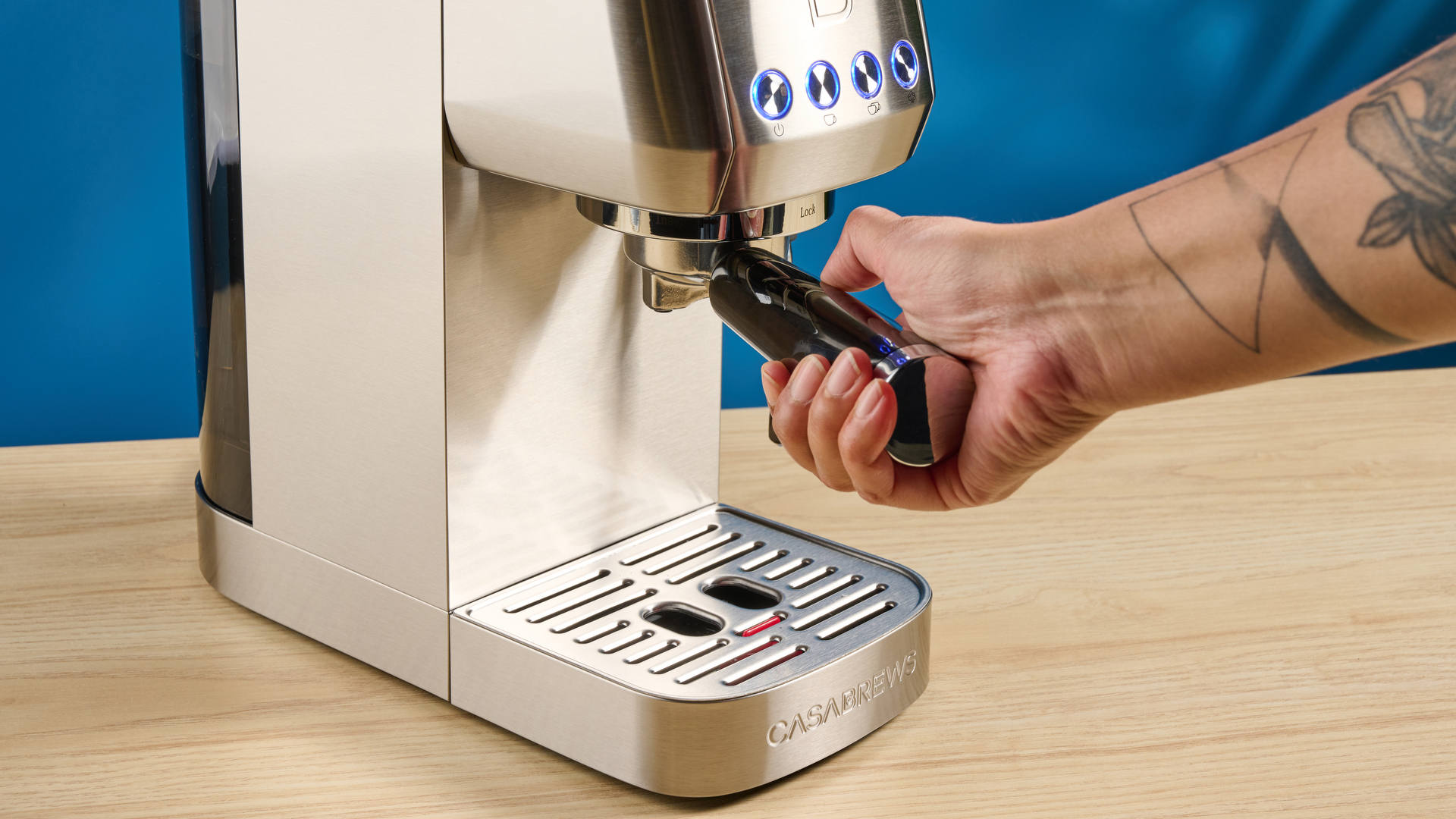 the casabrews 3700 essential espresso machine photographed against a blue background in stainless steel