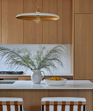 Wooden kitchen with a vase of branches and a bowl of lemons