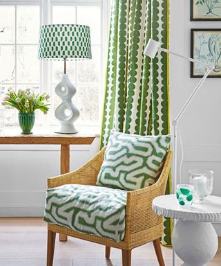 Chair in small green and white living room with white walls and green furnishings.