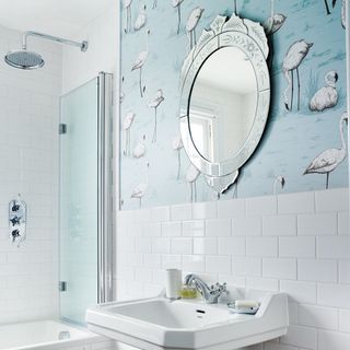 bathroom with swan designed wall wash basin mirror on wall and shower
