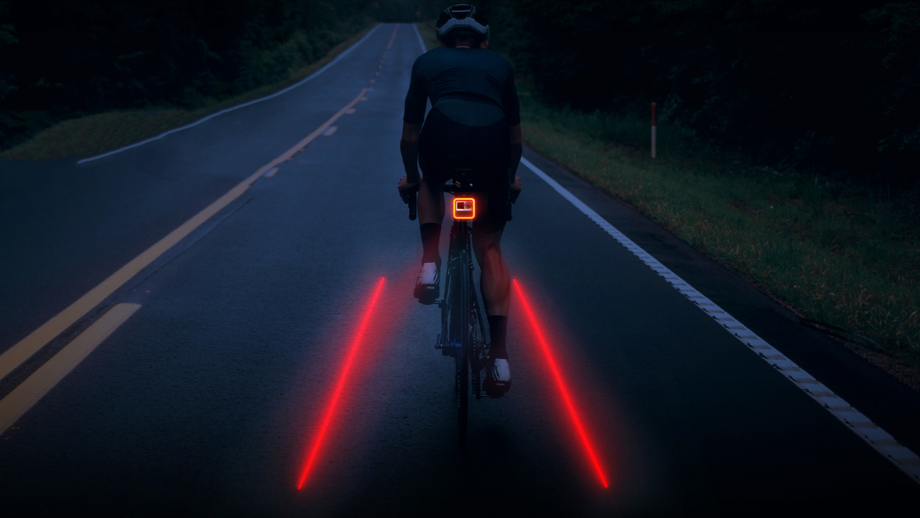 A cyclist riding in the dark with laser bike lanes