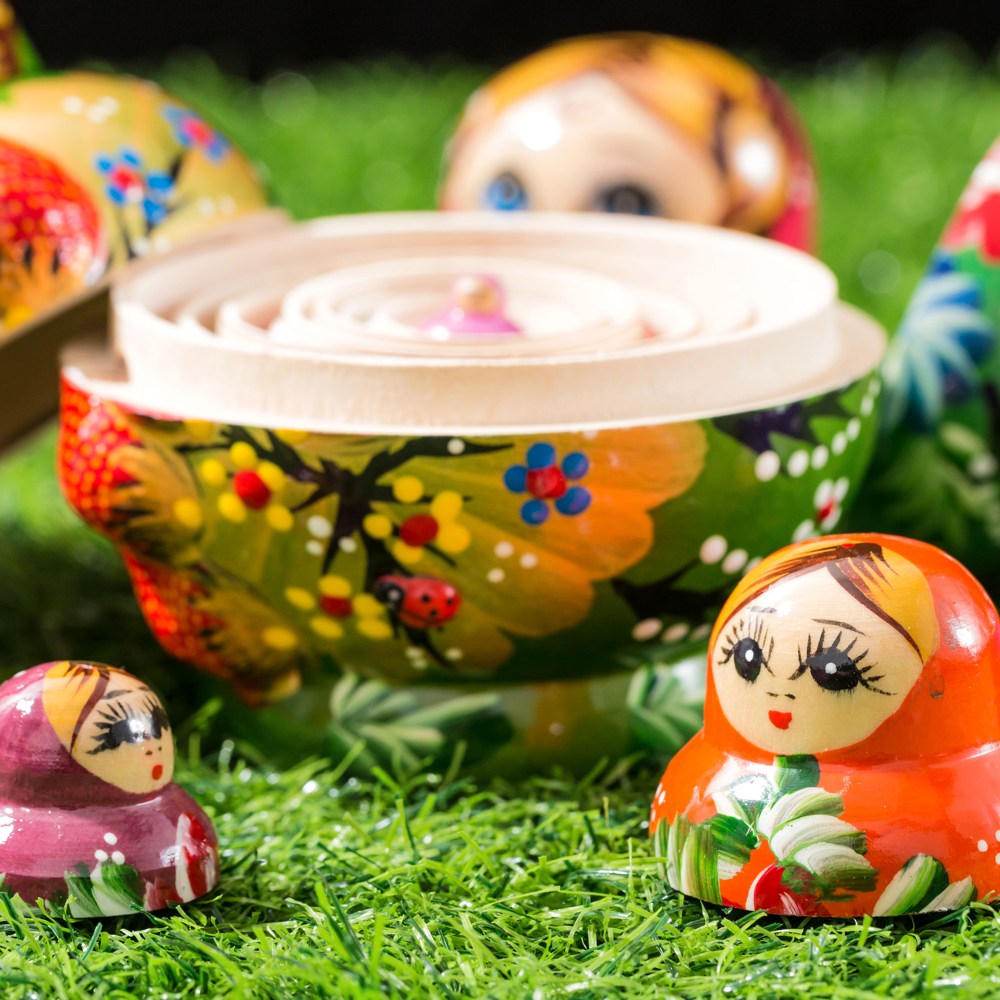 Russian dolls split apart showing central doll on grass
