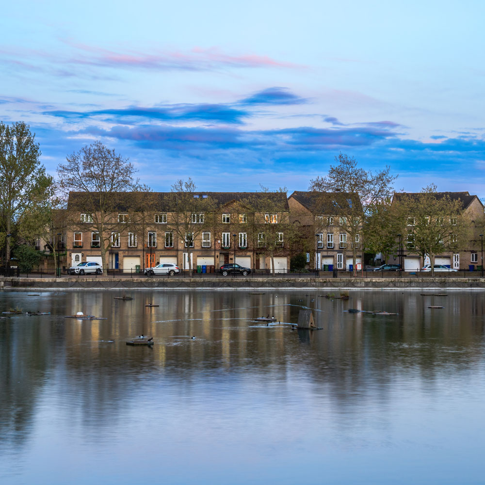 river with blue sky and trees on road with big house