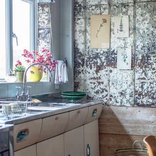 view of sink area in retro kitchen with salvaged tin wall tiles