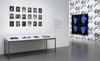Installation view of art and commerce exhibit at the Hirshhorn Museum and Sculpture Garden with portrait of Andy Warhol pictured right