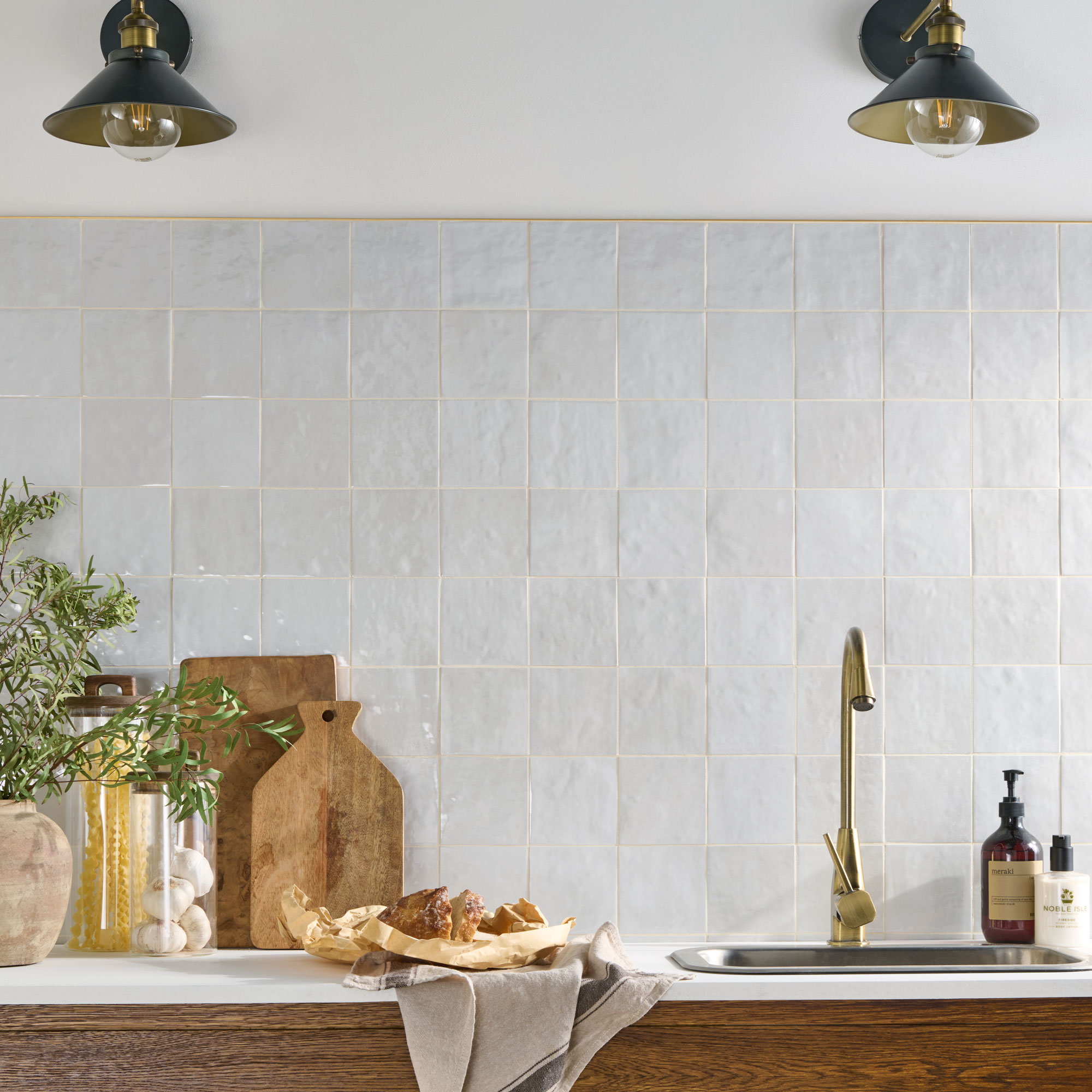 White zellige effect tiles behind a kitchen sink