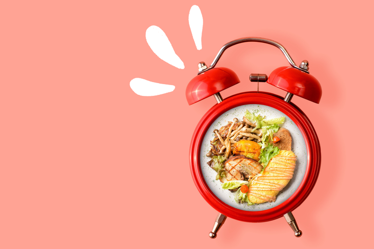 clock with food on a pink background to represent intermittent fasting and the 16:8 diet