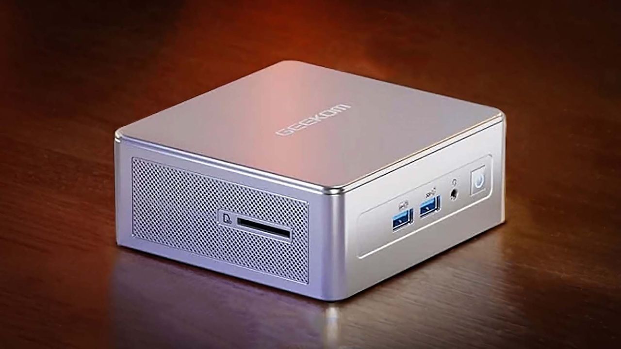 Geekom AE8 AI Mini PC on a wooden desk.