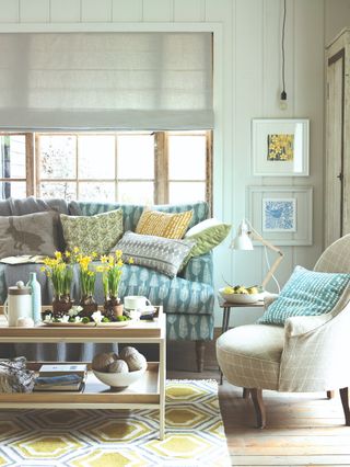 A living room with spring decor and couch with lots of scatter pillows