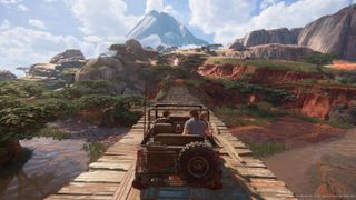 uncharted legacy of thieves collection image, a jeep drives across a wooden bridge in a red-rock valley with scrubby trees