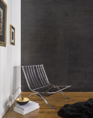 a chair in front of a black wall