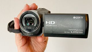 Sony HDR-CX405 camcorder being held in a woman's hand