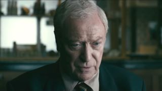 Michael Caine looks up somberly while sitting in Harry Brown.