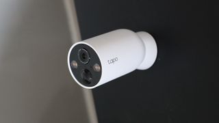 TP-Link Tapo C425 security camera mounted on a black wall