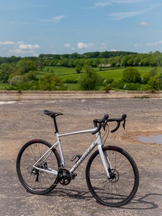 A white specialized allez stands on a rocky surface