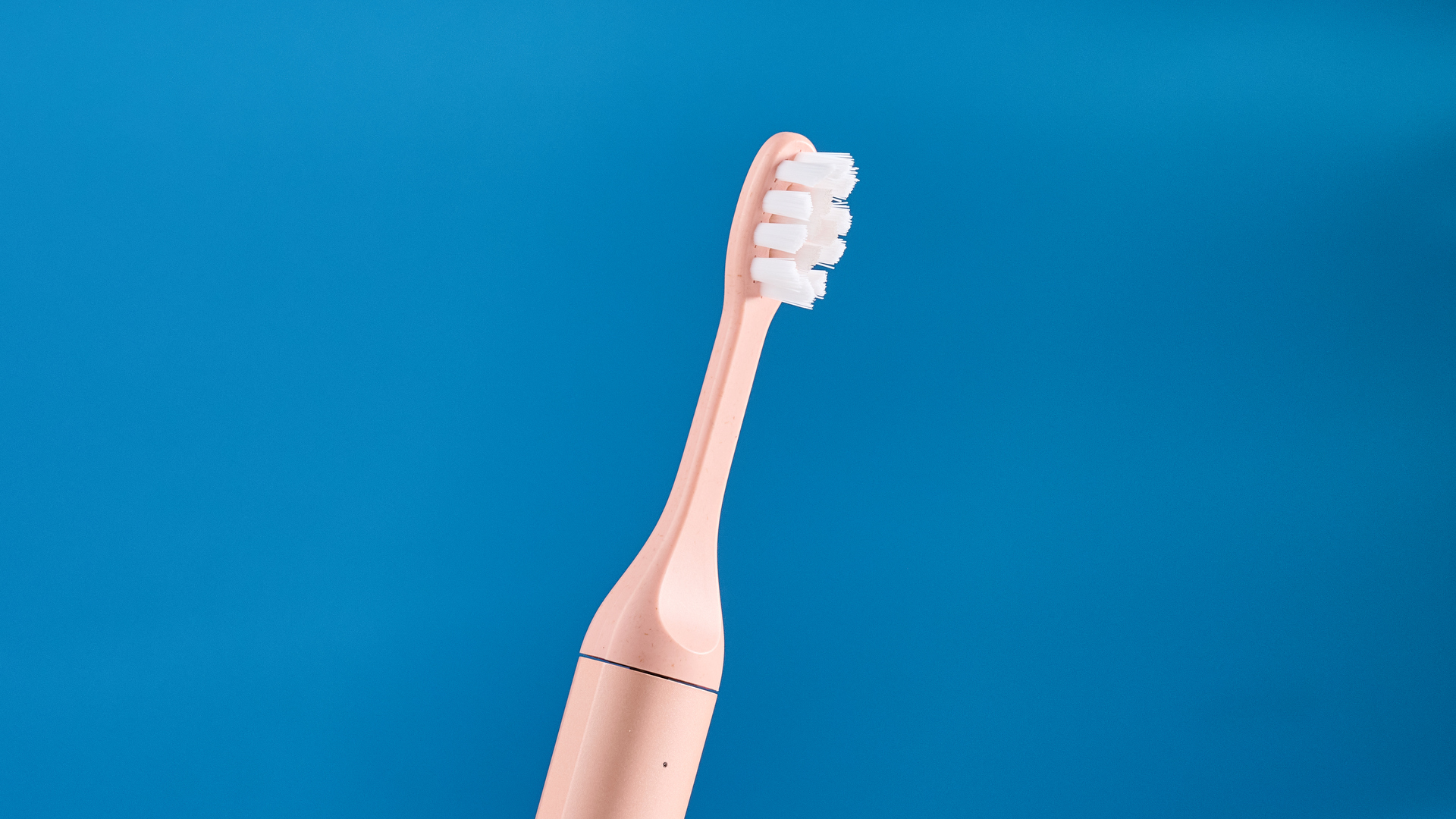 the Suri 2.0 toothbrush in sunset bloom pink colorway with a plant-based head and aluminum body, pictured with its uv cleaning travel case and the suri toothpaste