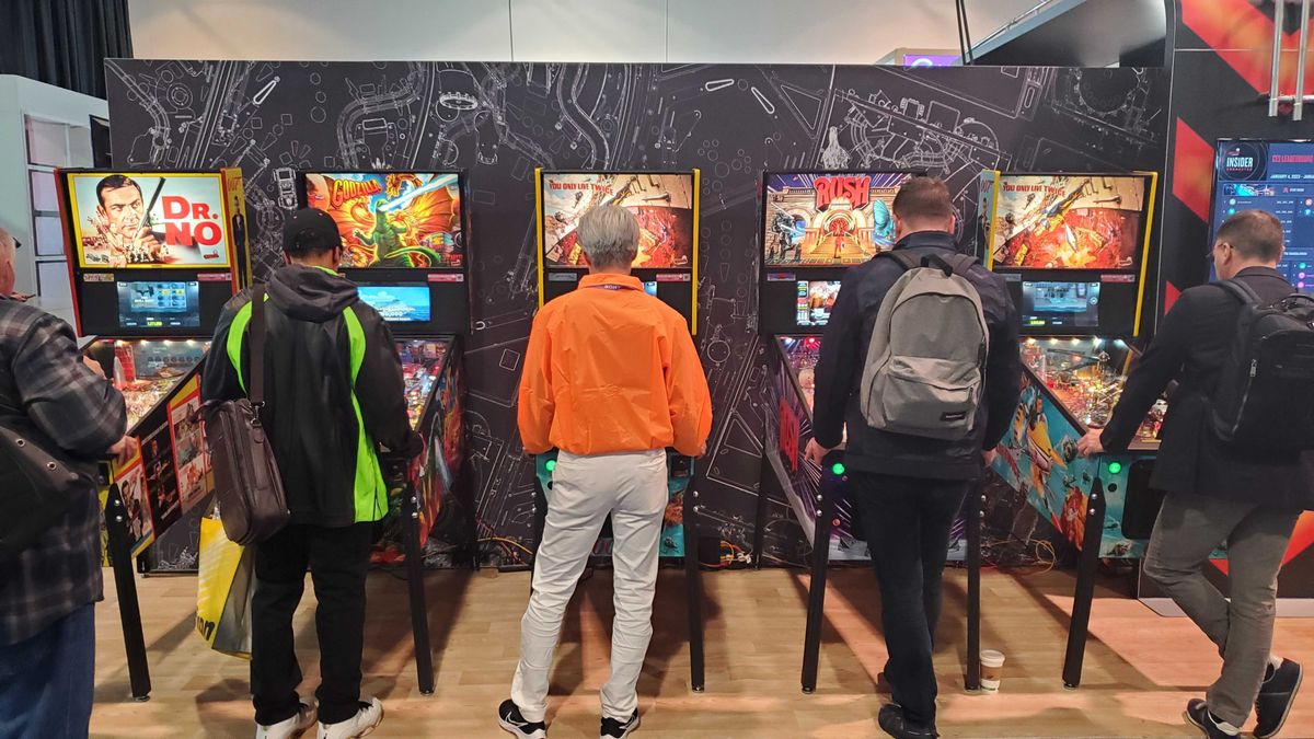 people playing pinball machine lit up
