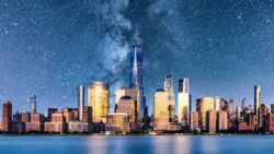 A view of NYC with a composite of a super starry sky behind.